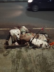 Teks Alt: Kondisi jalan Swadaya Raya Larangan Tangerang yang rusak dan berlubang akibat bekas galian kabel optik di depan Apotek Syifa, mengancam keselamatan pengendara motor pada Senin 19 Januari 2026.