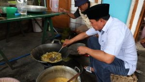Bupati Tangerang Moch. Maesyal Rasyid sedang memasak di kuali besar bersama ibu-ibu di dapur umum pengungsian Perumahan Taman Cikande Jayanti saat meninjau banjir yang merendam 119 desa di Januari 2026.