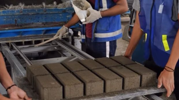 Warga binaan Lapas Kelas I Tangerang mengenakan rompi kerja sedang mencetak paving block dari limbah FABA di bengkel kerja lapas, menunjukkan proses kemandirian dan produktivitas narapidana.