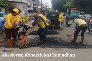 Petugas Dinas PUPR Kota Tangerang sedang melakukan penambalan aspal pada lubang jalan di Jembatan Berendeng untuk keamanan berkendara warga.