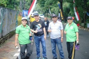 Camat Larangan Nasrullah bersama warga dan petugas kelurahan sedang mengecat kastin jalan dan membersihkan sampah di wilayah Kreo Selatan dalam rangka HUT ke-33 Kota Tangerang.