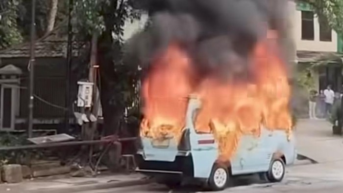 Bangkai angkot yang hangus terbakar di pinggir Jalan KH Mas Mansyur dengan garis polisi melingkari lokasi kejadian.