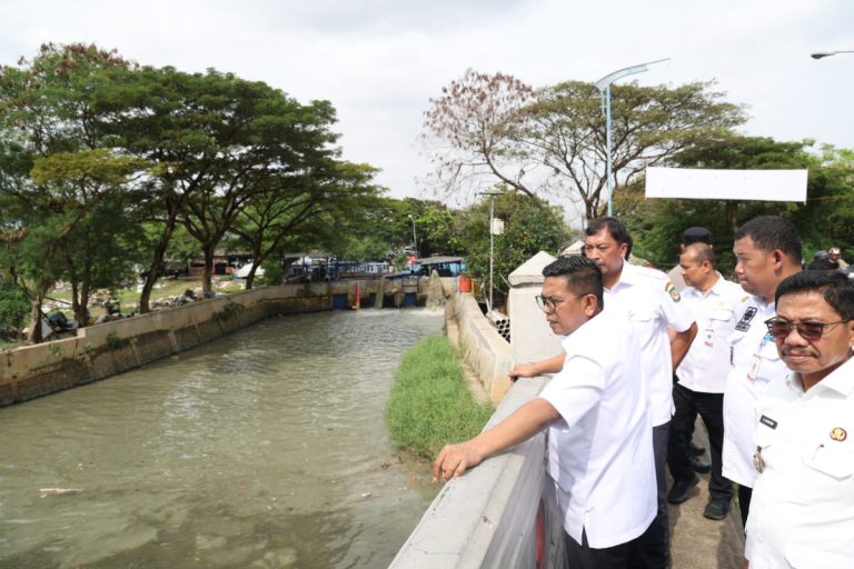 Deretan warung semi-permanen di pinggiran Situ Bulakan yang mulai dibongkar sendiri oleh pemiliknya di samping alat berat yang sedang mengeruk danau.