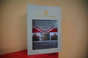 Kepala BPKAD Kota Tangerang Agus Andriansjah memegang dokumen LKPD bertuliskan opini Wajib Tanpa Pengecualian dari BPK RI dengan latar belakang logo Kota Tangerang dan grafik pertumbuhan realisasi pendapatan daerah 2025.
